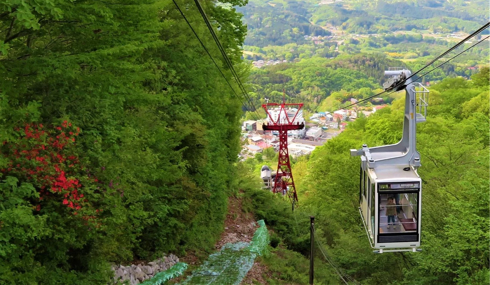 伊香保纜車行駛於山林間俯瞰溫泉街與遠方山景